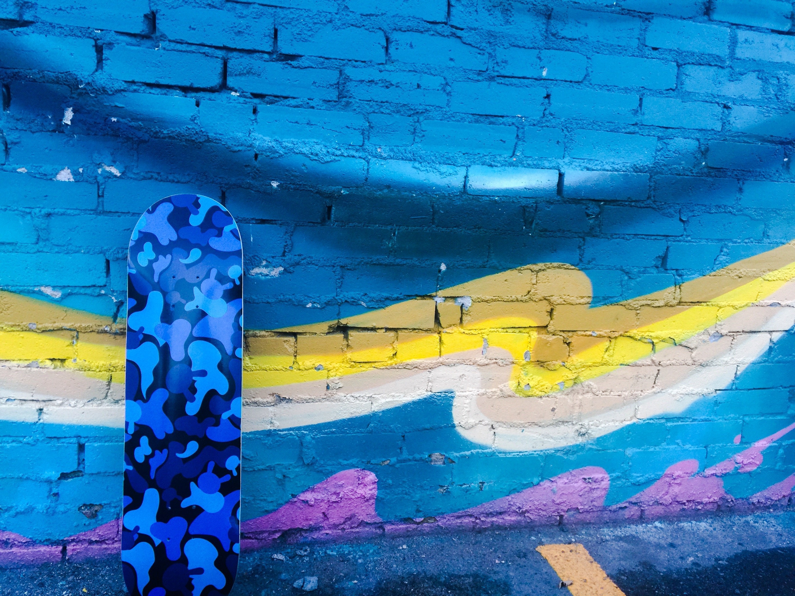 Limited Edition Kidrobot Camo Dunny skateboard deck by Tristan Eaton with blue camouflage design on wood surface.